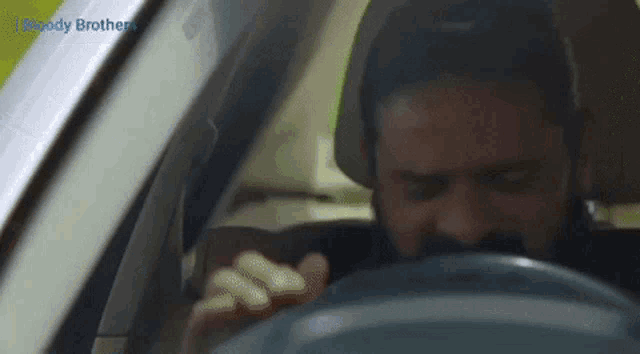 a man driving a car with the word bloody brothers written on the bottom
