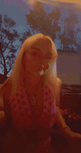 a woman in a pink top with hearts on it is dancing