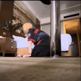 a man is kneeling on the floor in a hotel room looking at something .
