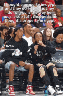 a man and a woman sit in the stands at a basketball game