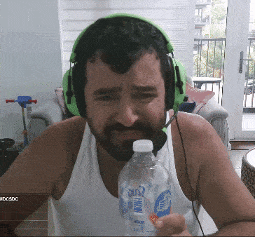 a man wearing headphones holds a bottle of aquafina