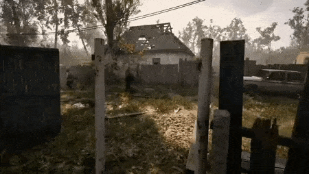 a man is walking through a fence in front of a destroyed house .