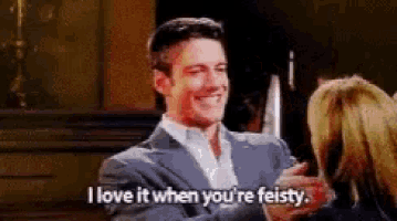 a man in a suit is talking to a woman in a room .