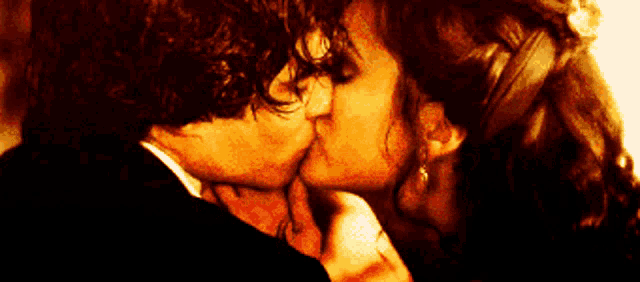 a man and a woman are kissing and the woman is wearing earrings