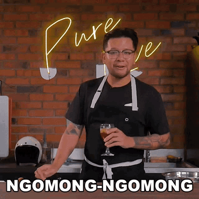 a man in an apron is holding a glass of wine in front of a sign that says pure