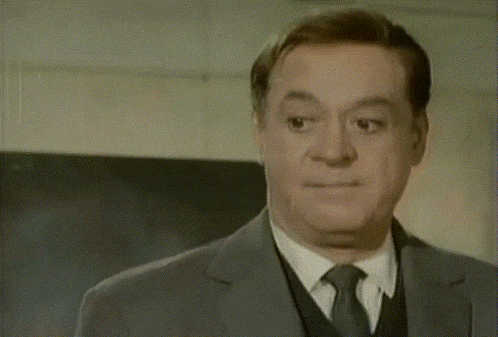 a man in a suit and tie making a face