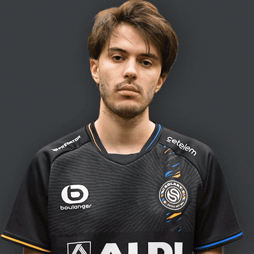 a man wearing a black shirt that says aldi pointing at the camera