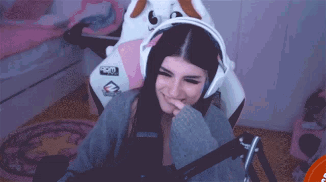 a woman wearing headphones is sitting in a chair with a sticker that says pro