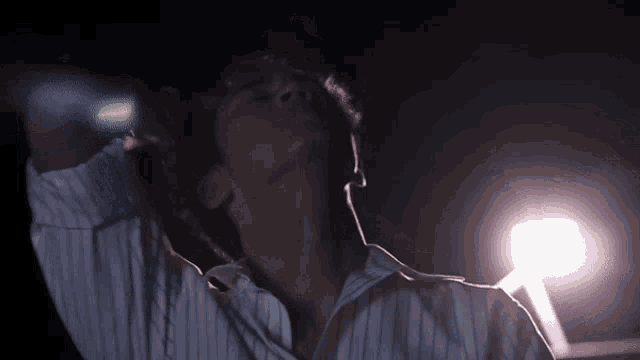 a man in a striped shirt is looking up at the sky