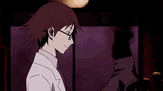 a man wearing glasses is hugging another man in a dark room
