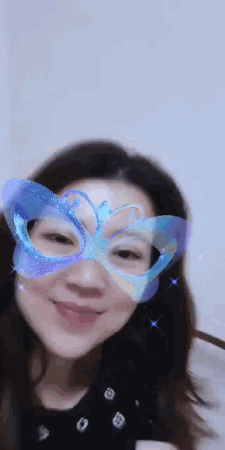 a woman wearing a butterfly mask on her face