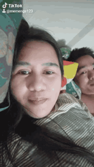 a man and a woman are laying on a bed with a tik tok watermark