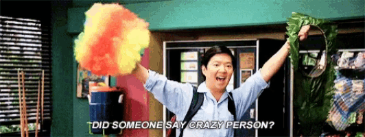 a man in a blue shirt is holding a rainbow colored object in his hands and says did someone say crazy person