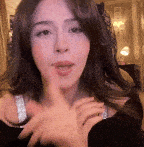 a close up of a woman 's face with a finger on her mouth