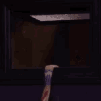 a man is looking out of a window while holding a towel