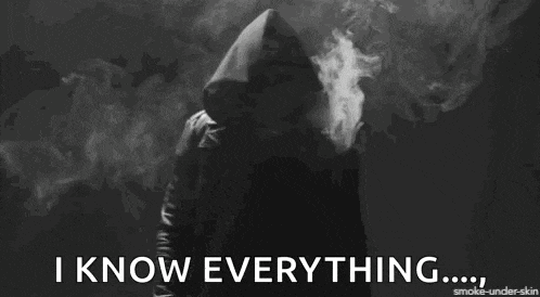 a man in a hood is smoking a cigarette and says i know everything .