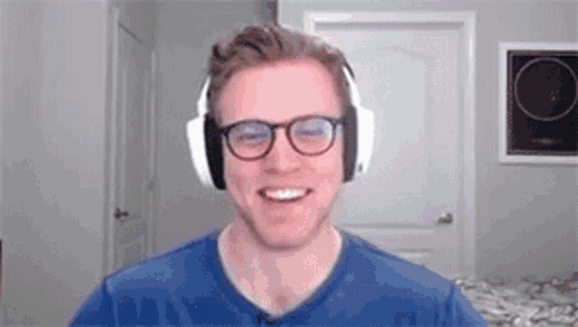 a man wearing headphones and glasses is smiling while talking on a video call .