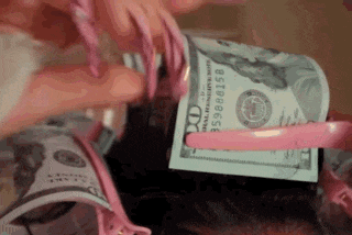 a woman with long pink nails is holding a stack of money in her hand .