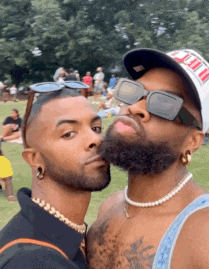 a man with a beard is kissing another man on the cheek .
