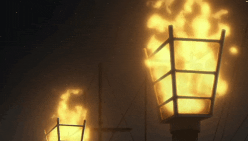 a lamp post with a flame coming out of it in the dark