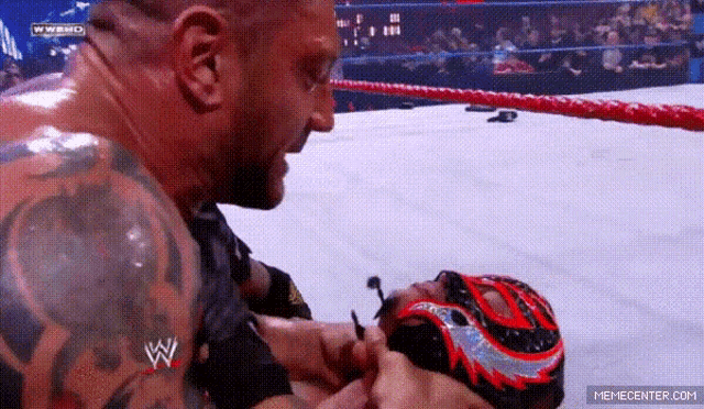 a man with a tattoo on his arm is wrestling another man in a ring .