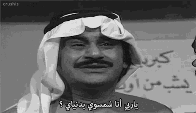 a black and white photo of a man in a turban with arabic writing on his face