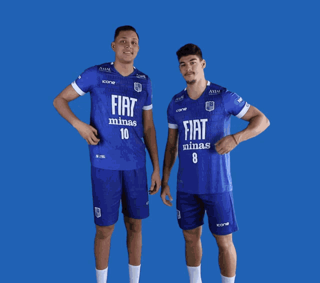 two men wearing blue fiat minas jerseys pose for a photo