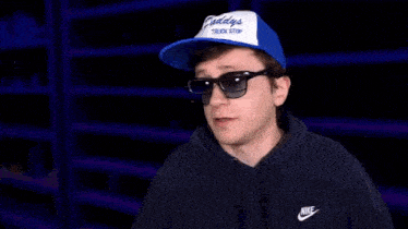 a man wearing sunglasses and a hat with a youtube subscribe button behind him