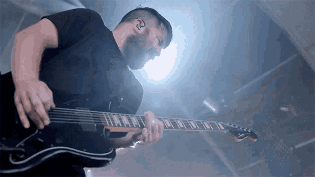 a man with a beard is playing a guitar with the number 3 on his ear