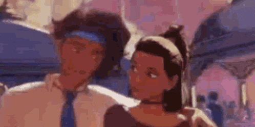 a man and a woman are standing next to each other and looking at each other in a blurry picture .