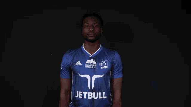 a man in a blue adidas shirt is holding a poster