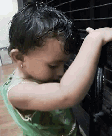 a little girl in a green tank top is playing with a toy