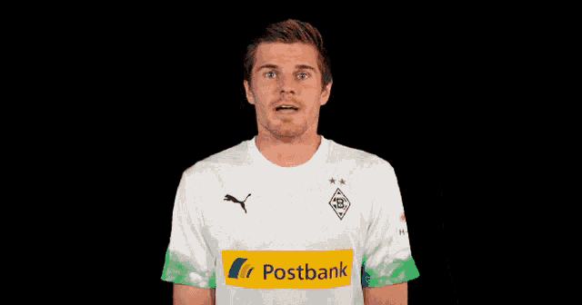 a man wearing a white shirt with a postbank logo on the front