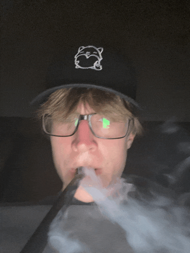 a man wearing glasses and a hat is smoking a pipe