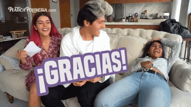 a group of people sitting on a couch with a sign that says " gracias "