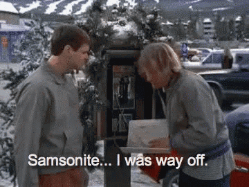 two men are standing next to each other in front of a pay phone and one of them is saying samsonite i was way off