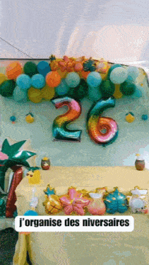 a table decorated with balloons and a sign that says j'organise des niversaires