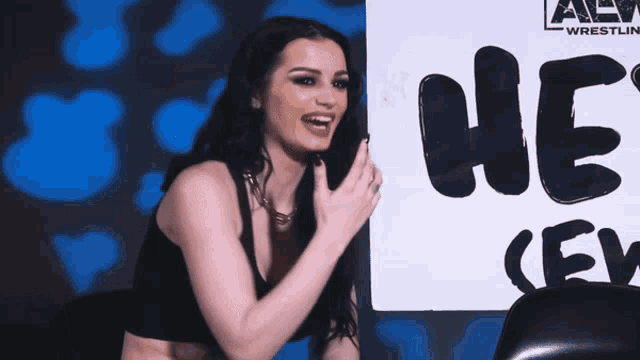 a woman is laughing in front of a sign that says we