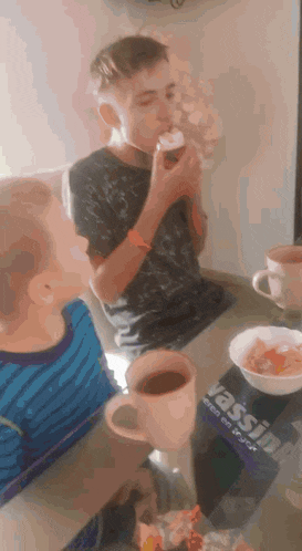two young boys are sitting at a table with cups of coffee and a book called vassilyn