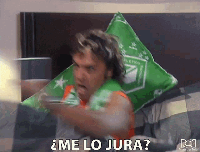a man laying on a bed with a green pillow that says ' me lo jura ' on it