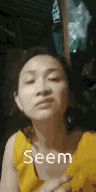 a woman in a yellow shirt is making a face and says seem