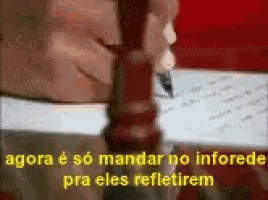 a close up of a person writing on a piece of paper with the words agora e so mandar no informed pra eles refletirem