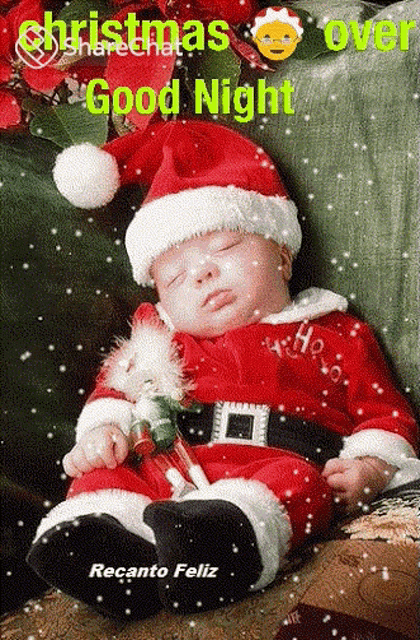 a baby dressed in a santa suit is sleeping on a couch