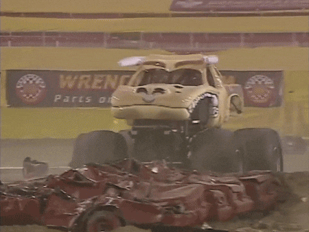 a monster truck that looks like a dog is driving on a dirt road