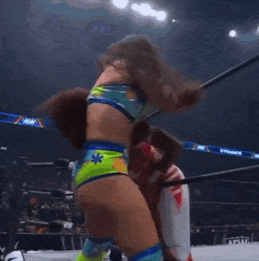 a woman in a bikini is wrestling another woman in a dynamite ring