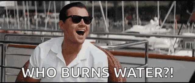 a man wearing sunglasses is laughing while sitting on a boat and says `` who burns water ? ''