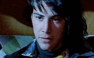 a close up of a man 's face wearing a scarf and a tie .