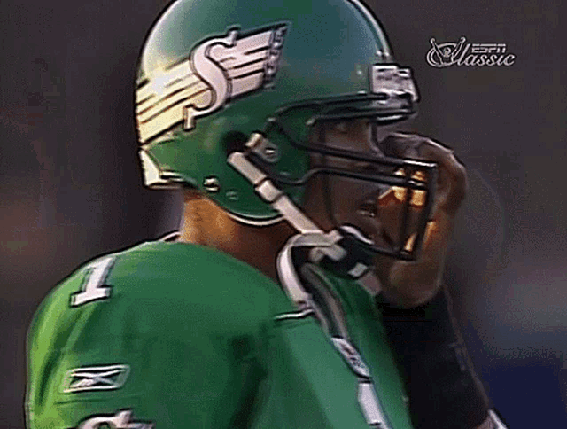 a football player wearing a green jersey and a helmet with the letter s on it