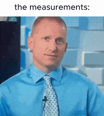 a man in a blue shirt and tie is talking into a microphone with the words " the measurements " below him