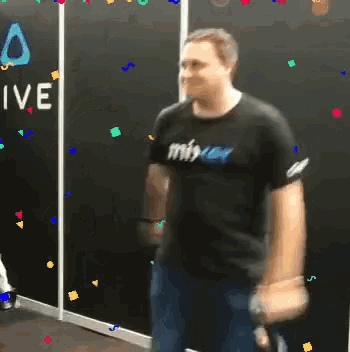 a man is dancing in front of a wall that says vive